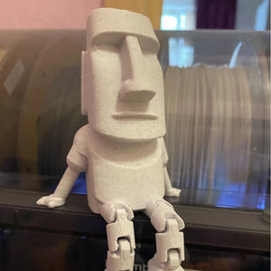 Gros plan de face de la figurine Moai grise au corps articulé