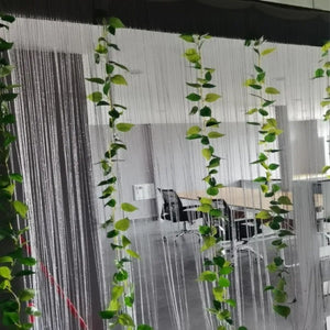 Rideau à fils installé comme cloison décorative dans un intérieur lumineux