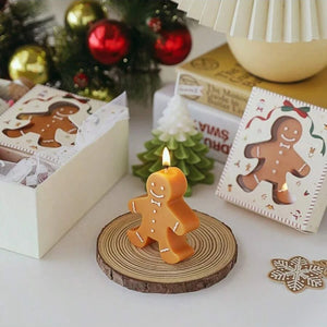 Bougie pain d'épice allumée sur tranche de bois entourée de décorations Noël avec sapin et boules