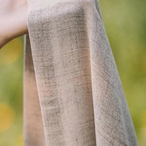 Texture du tissu beige du rideau tenu à la main en extérieur