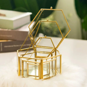 Trois boîtes à bijoux hexagonales de tailles différentes empilées sur un tapis doux