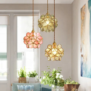 Trois suspensions fleur en verre coloré style Tiffany allumées au-dessus d'une table