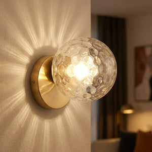 Applique murale boule de verre transparent bosselé au socle doré