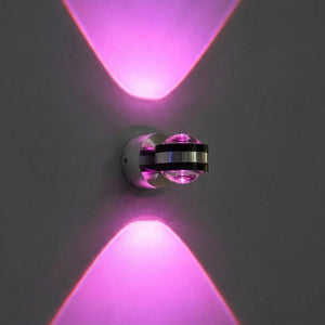 Applique murale LED ronde en lumière rose allumée sur un mur sombre