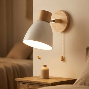 Applique murale nordique blanche en bois et métal orientable allumée au chevet