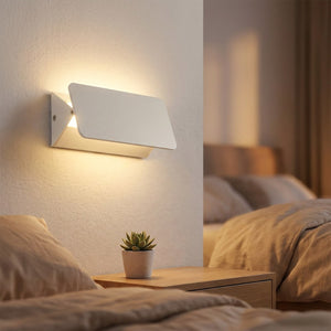 Applique murale LED blanche au dessus d'une table de chevet dans une chambre chaleureuse
