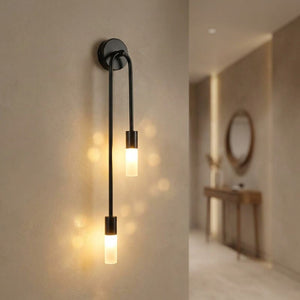 Applique murale noire allumée dans un couloir avec miroir rond et console