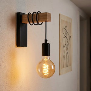 Applique murale noire dans un couloir à côté d'un cadre décoratif graphique
