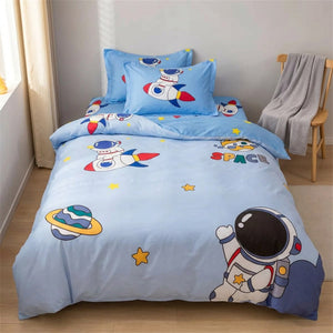 Parure de lit enfant astronaute dans une chambre cocooning avec chaise en bois et plaid