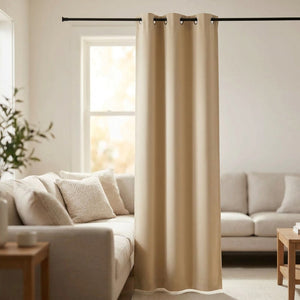 Rideau occultant beige à œillets suspendu à une tringle devant une fenêtre dans un salon lumineux