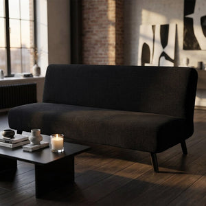 Housse de canapé lit futon noire dans un loft moderne avec bougie