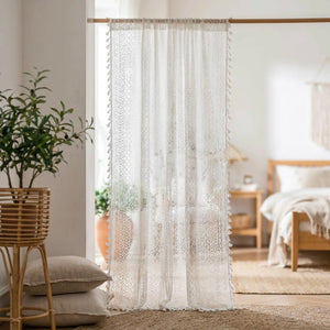 Rideau voilage boho en dentelle au crochet blanc à pompons suspendu à une fenêtre