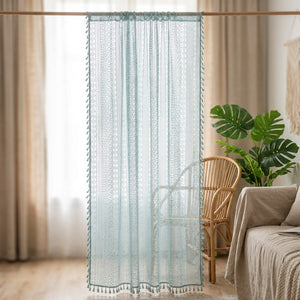 Rideau voilage boho en dentelle au crochet bleu ciel à pompons suspendu à une fenêtre