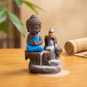 Brûleur d'encens à reflux en céramique avec petit moine bouddha à la robe bleue et cascade de fumée
