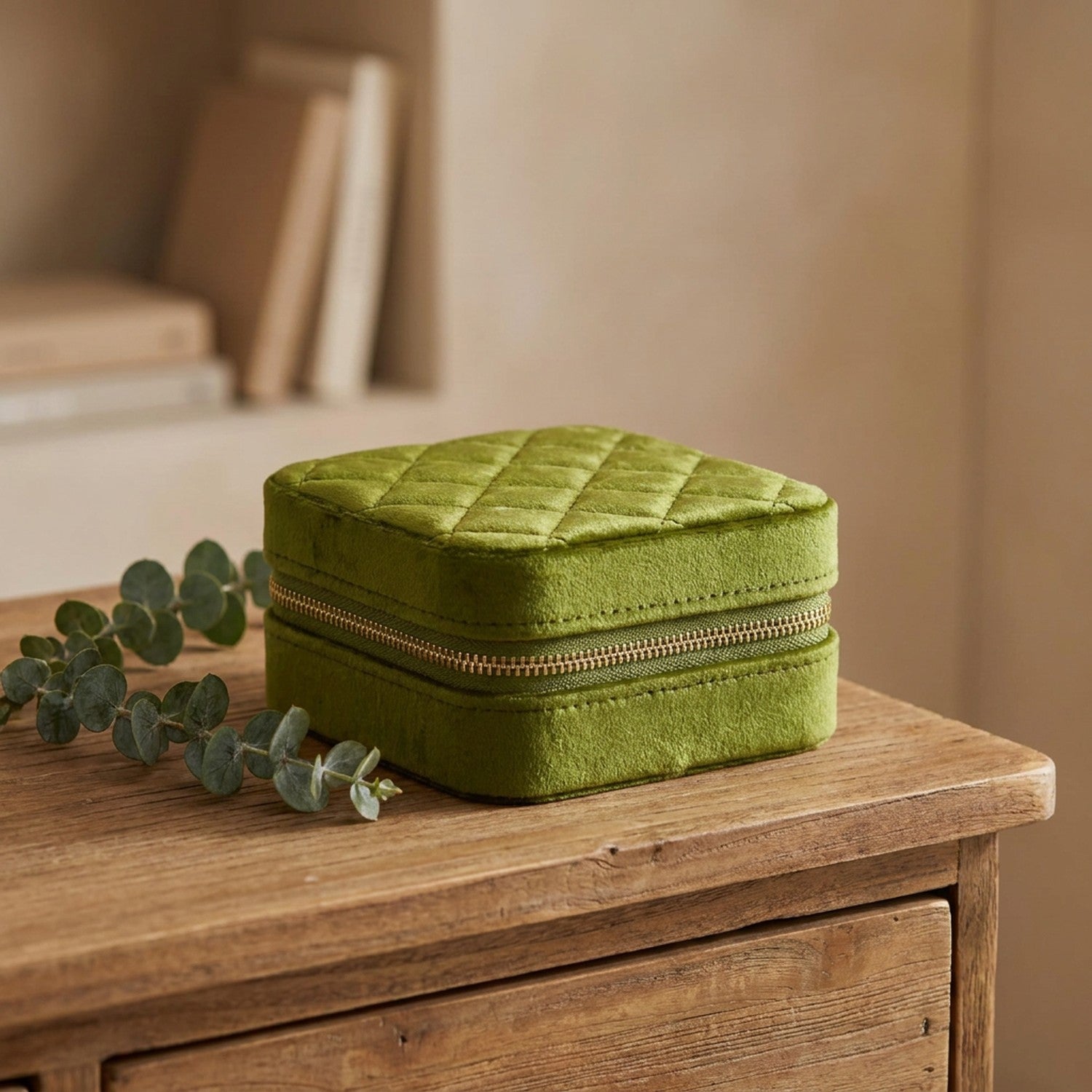 Boîte à bijoux en velours vert olive posée sur une commode en bois