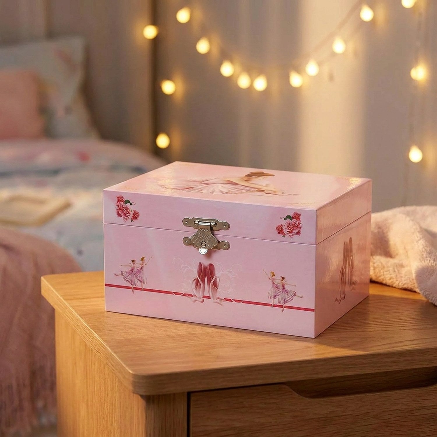 Boîte à musique ballet rose sur table de nuit avec guirlande lumineuse bokeh