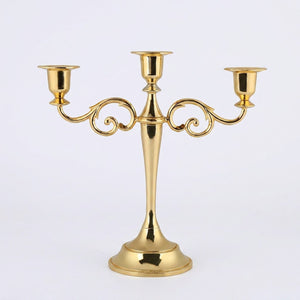 Bougeoir chandelier 3 branches sur surface dorée ambiance chaleureuse