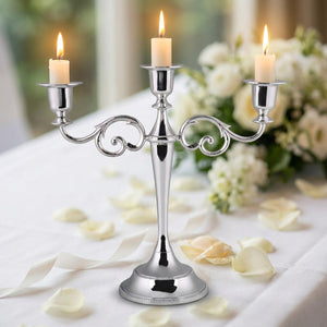 Bougeoir chandelier métal argent sur table de mariage avec pétales de roses blanches