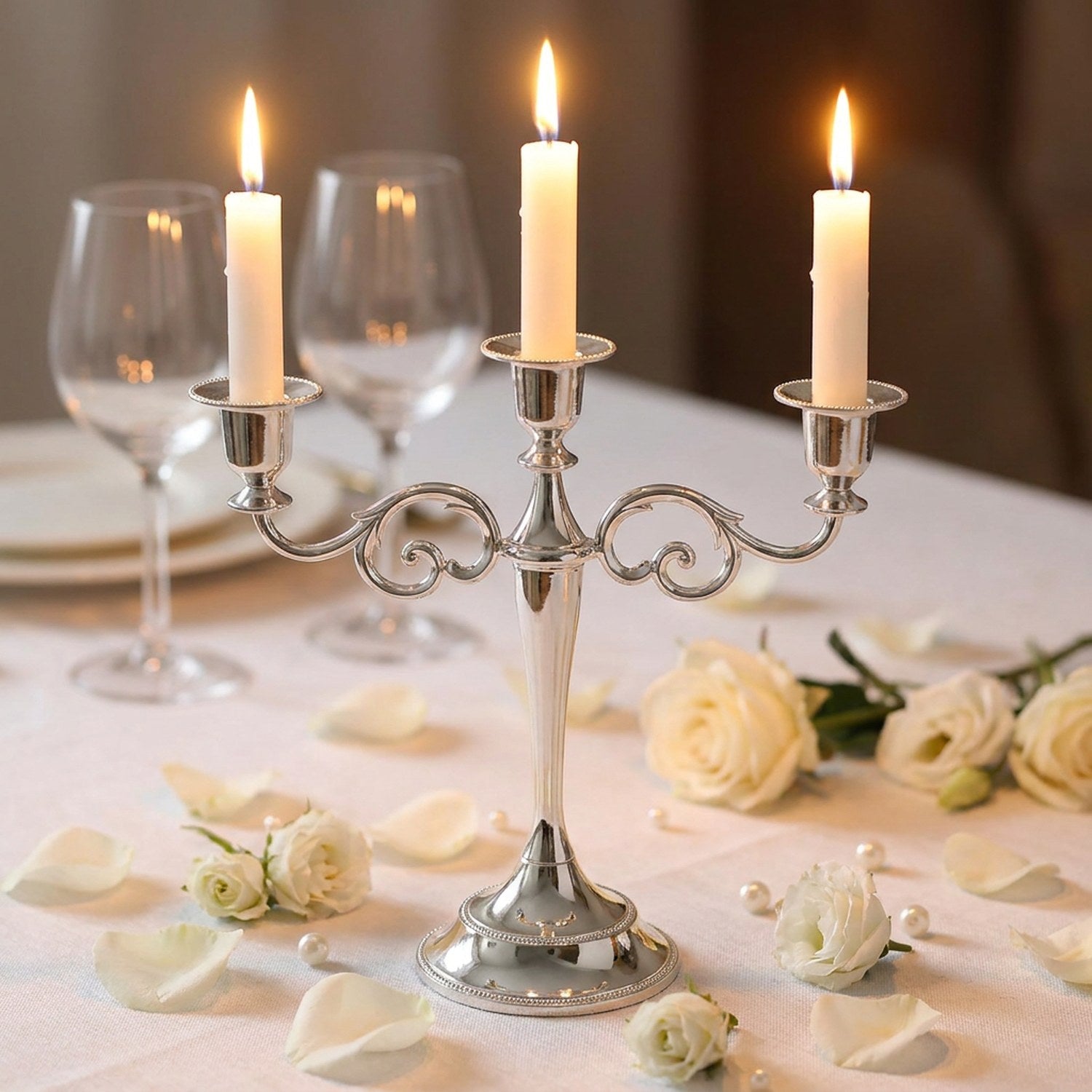 Bougeoir argenté 3 bras sur table de mariage avec roses blanches et pétales