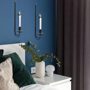 Bougeoirs muraux fer forgé noir au-dessus d'un lit dans chambre bleue