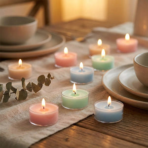 Bougies parfumées pastel allumées sur une table de dîner décorée