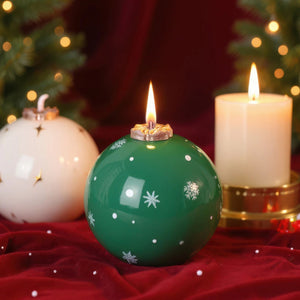 Bougie parfumée de Noël verte allumée sur velours rouge avec bougie blanche