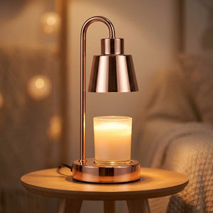 Lampe chauffe-bougie cuivrée allumée sur une petite table ronde en bois