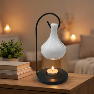 Brûle-parfum en céramique blanche suspendu sur une console de salon avec une plante