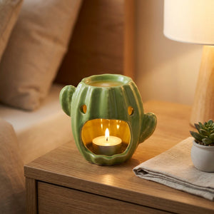 Brûle-parfum cactus en céramique allumé sur une table de chevet