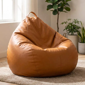Pouf poire en simili cuir cognac posé au sol dans un salon lumineux et chaleureux
