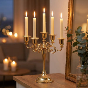 Chandelier doré à 5 branches sur une console près d'un miroir avec eucalyptus