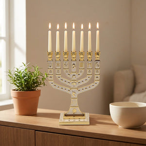 Chandelier menorah doré et blanc sur une console en bois près d'une plante verte
