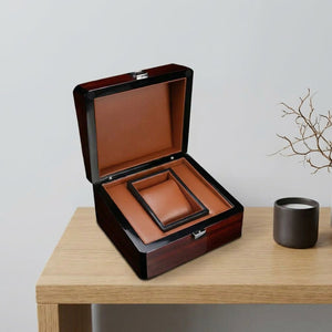 Coffret montre ouvert vue de dessus sur étagère bois avec bougeoir et branche décorative