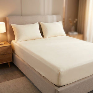 drap-housse en coton crème sur un lit