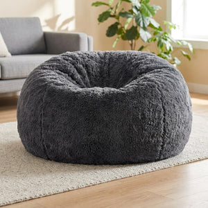 Pouf géant en fausse fourrure grise posé au sol dans un salon