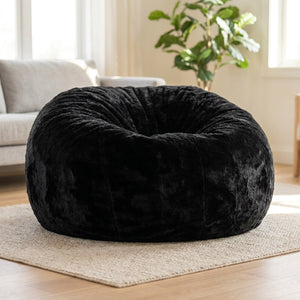 Pouf géant en fausse fourrure noire posé au sol dans un salon