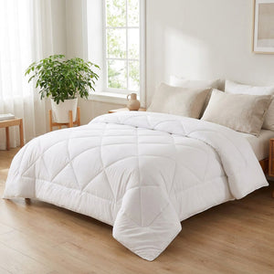 Couette en laine blanche sur un lit dans une chambre scandinave lumineuse avec une plante verte