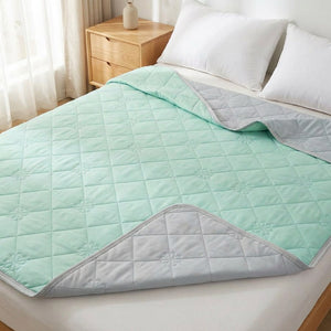 Couverture rafraîchissante d'été vert menthe réversible au matelassage fleur sur un lit