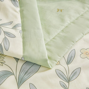 Détail de la bordure vert sauge et de la broderie sur la couette d'été