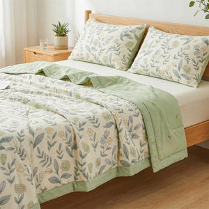 Couette d'été vert sauge dans une chambre moderne en bois clair avec plante