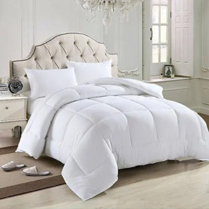 Couette blanche installée sur un lit avec oreillers assortis