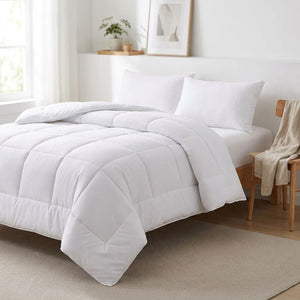 Couette blanche dans une chambre lumineuse avec chaise en bois