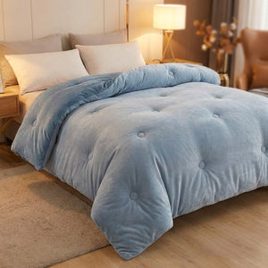 Couette bleu clair en velours de lait matelassée sur un lit dans une chambre douce