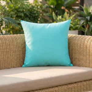 Housse de coussin d'extérieur turquoise imperméable de 45 cm posée sur un salon de jardin en résine tressée