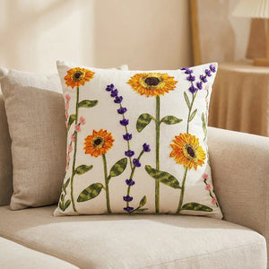 Housse de coussin motif tournesol et lavande posée sur un canapé