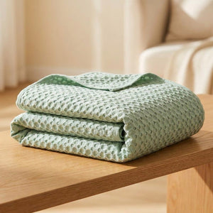 Couverture bambou verte pliée montrant son tissage nid d'abeille