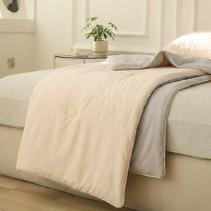 Couverture d'été rafraîchissante drapée au coin d'un lit dans une chambre épurée