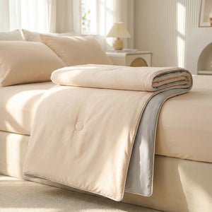 Couverture d'été rafraîchissante beige légère posée sur un lit dans une chambre lumineuse