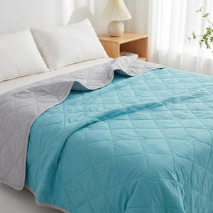 Couverture rafraîchissante d'été bleue au matelassage fleur posée sur un lit dans une chambre lumineuse
