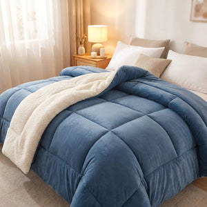 Couverture chaude réversible bleue en velours et effet mouton posée sur un lit dans une chambre chaleureuse
